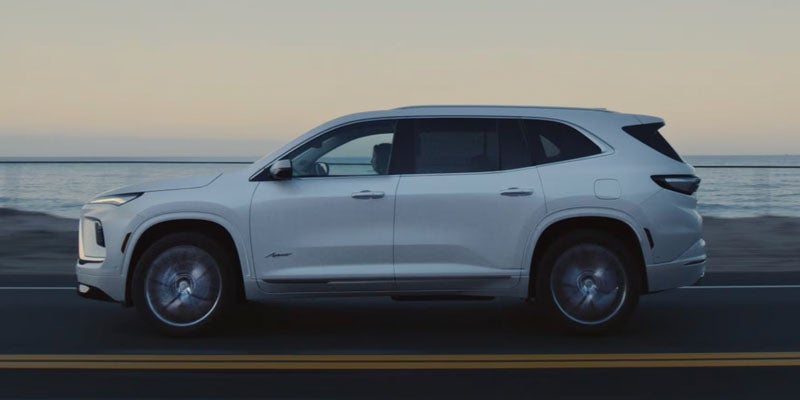 White Buick Enclave SUV shown in side profile on a roadway