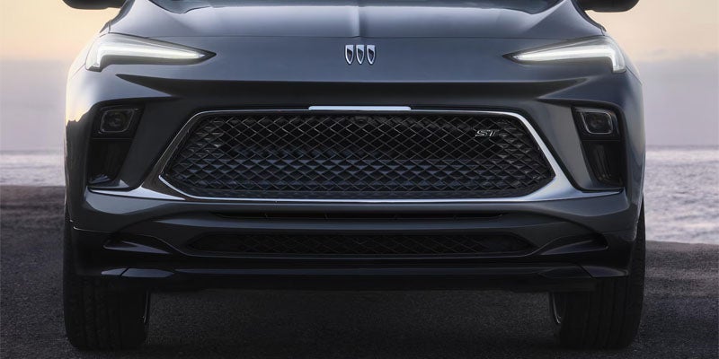 Close-up of Buick front grille with tri-shield emblem and mesh pattern design