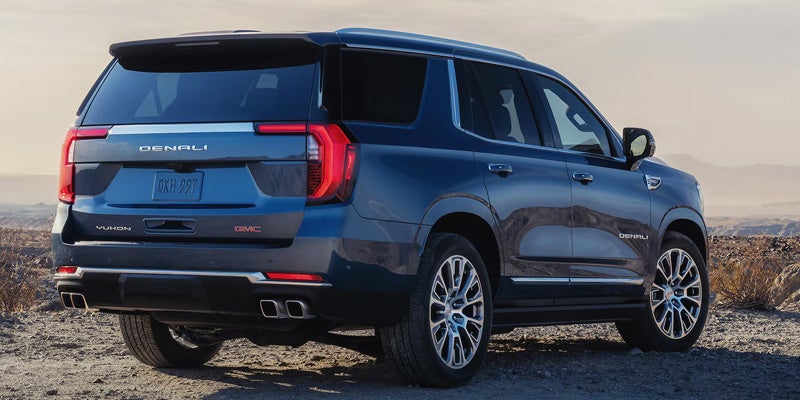 Rear three-quarter exterior view of a blue GMC SUV