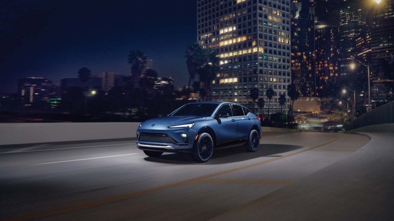 Blue Buick Envista compact SUV on a city overpass at night