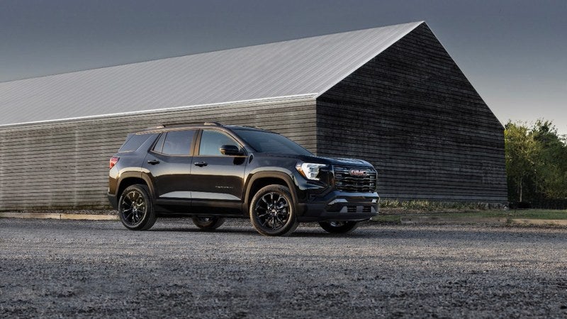 GMC Terrain SUVs parked in front of a barn or warehouse