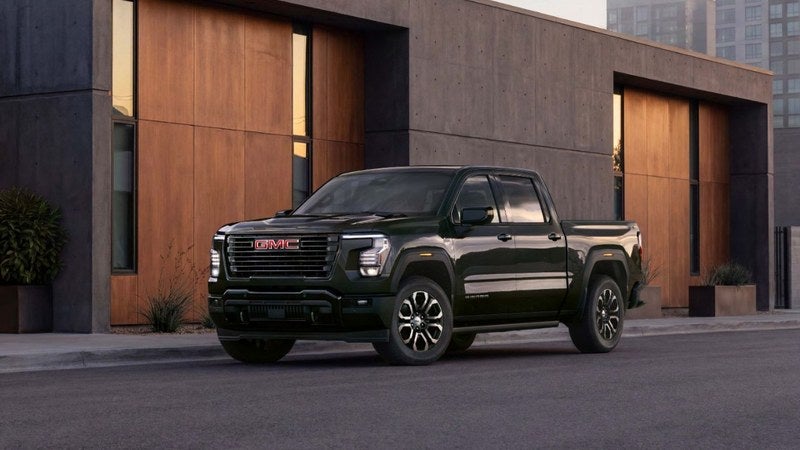 GMC Sierra 1500 pickup truck in front of a modern home