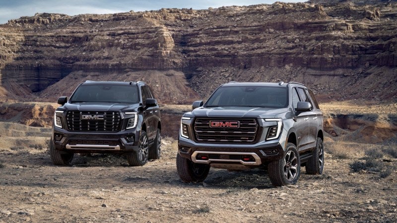 Black GMC Yukon Denali SUV in a mountain landscape