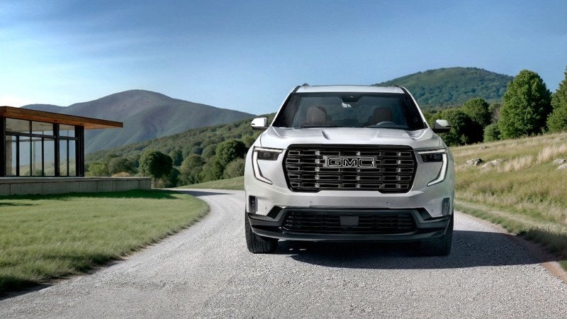White GMC Acadia SUV parked outside a modern home